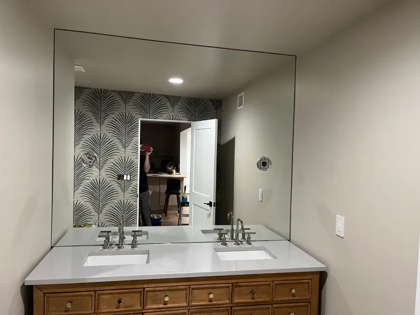 A bathroom with two sinks and a large mirror.