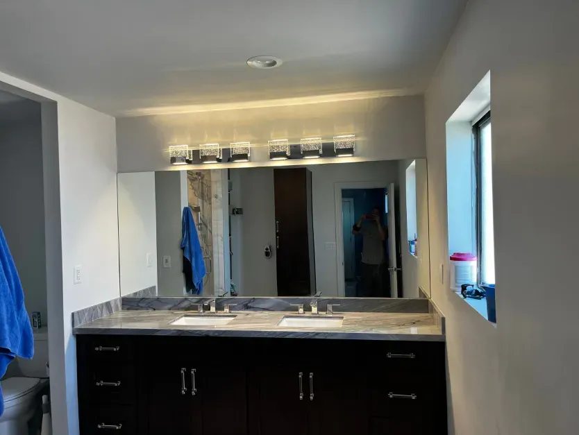 A bathroom with two sinks and a large mirror.