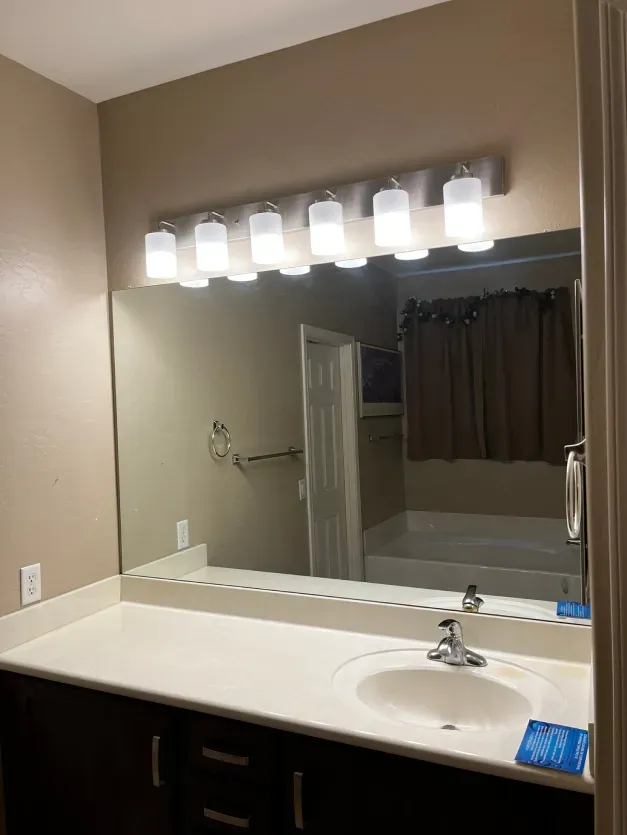 A bathroom with a sink and a large mirror