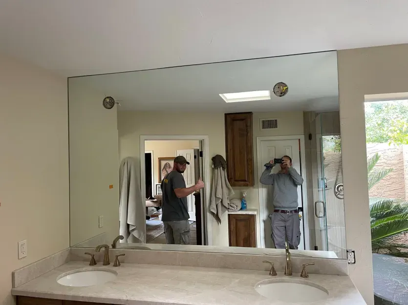 A bathroom with two sinks and a large mirror.