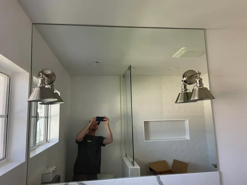 A man is taking a picture of himself in a bathroom mirror.