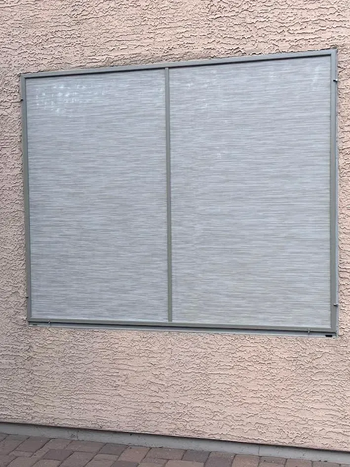 A large window on a brick wall with a metal frame.