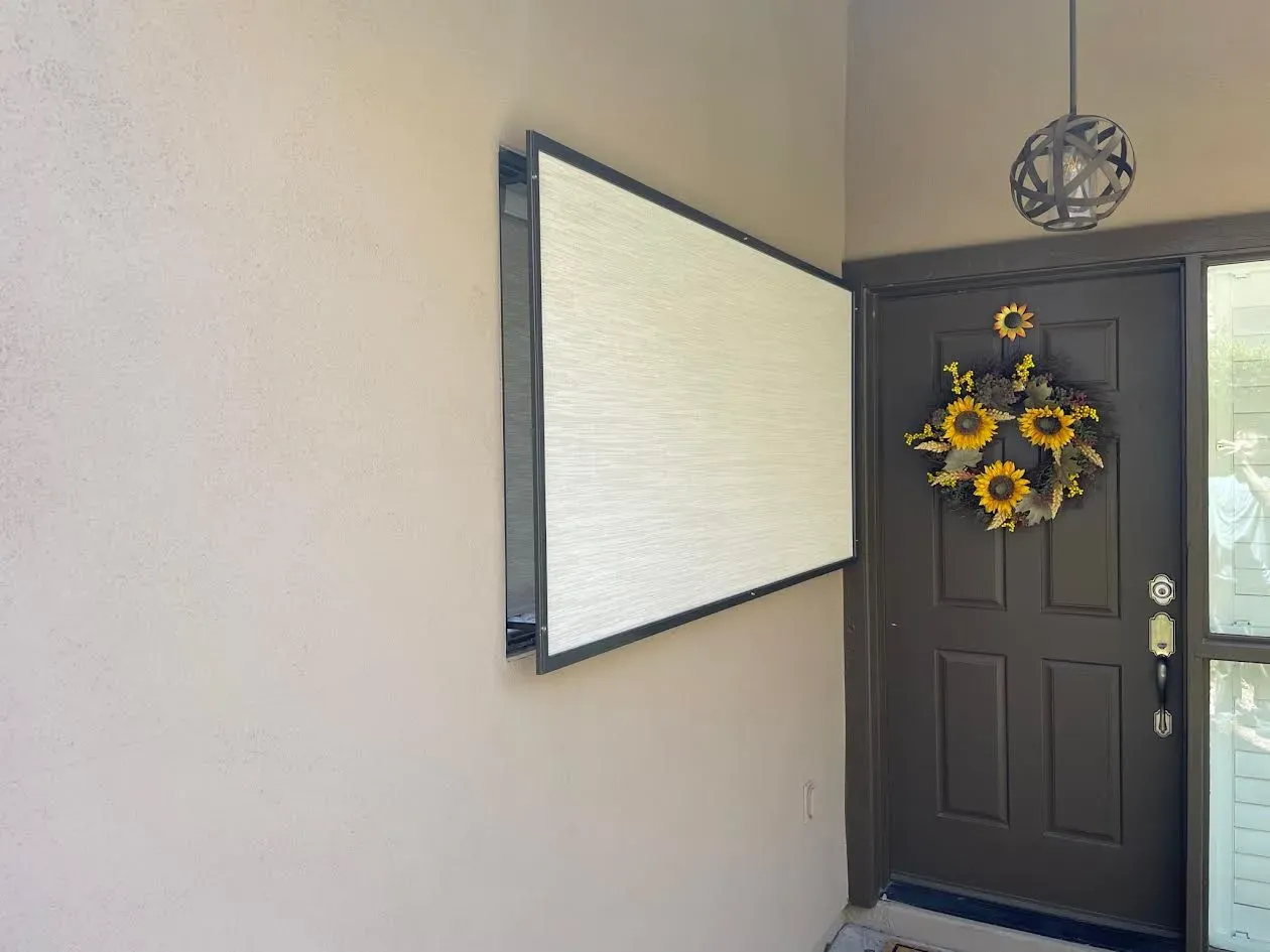A door with a wreath on it and a white board on the wall.