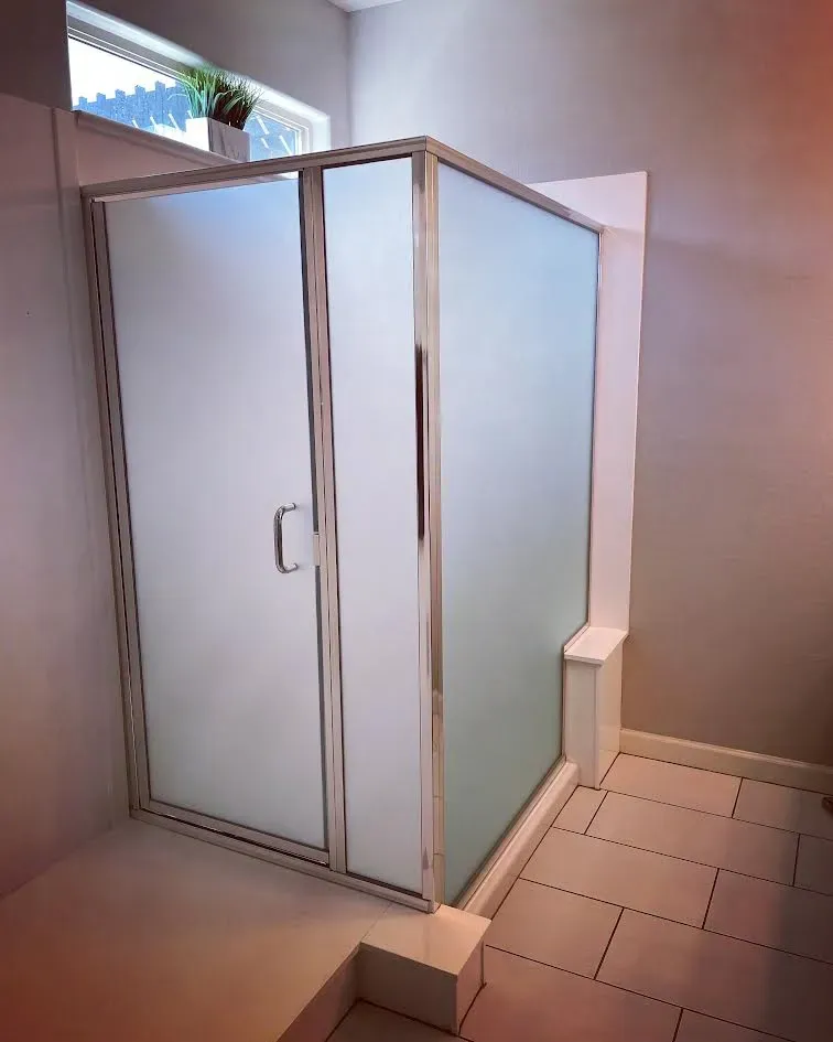 A bathroom with a sliding glass shower door