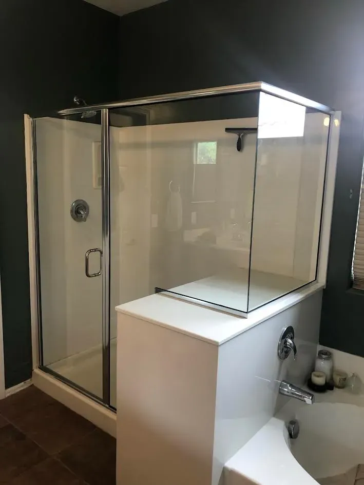 A bathroom with a walk in shower and a bathtub.