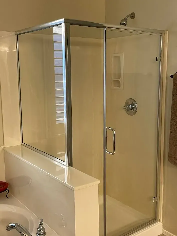 A bathroom with a glass shower door and a sink.