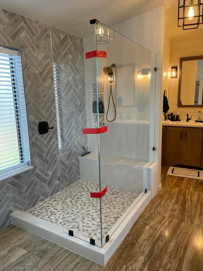 A bathroom with a walk in shower and a sink.