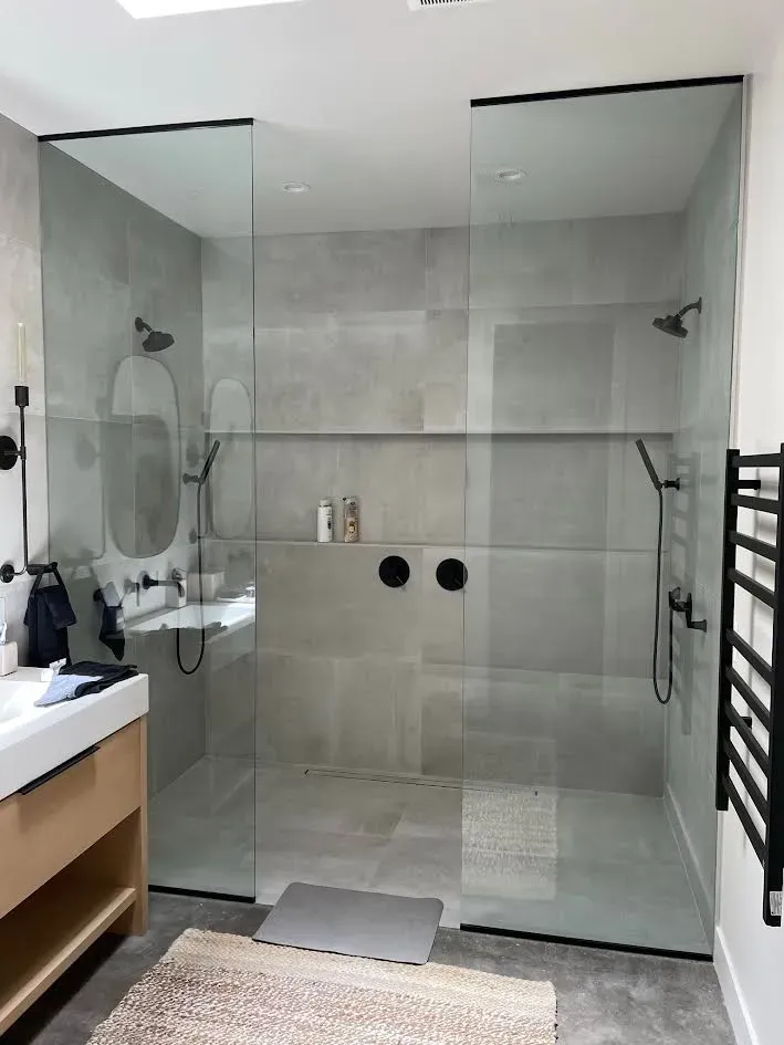 A bathroom with a walk in shower and a sink.