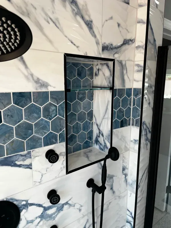 A bathroom with blue and white tiles and a shower head