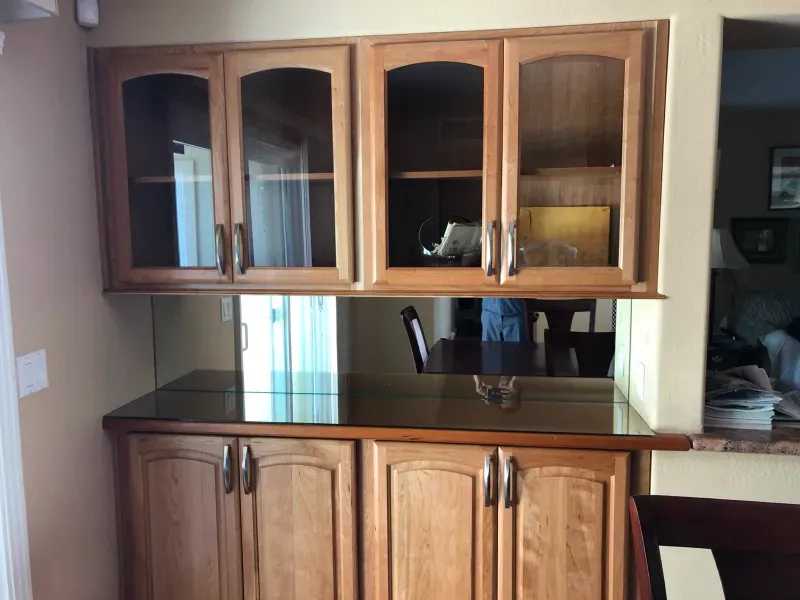 A kitchen with wooden cabinets and glass doors