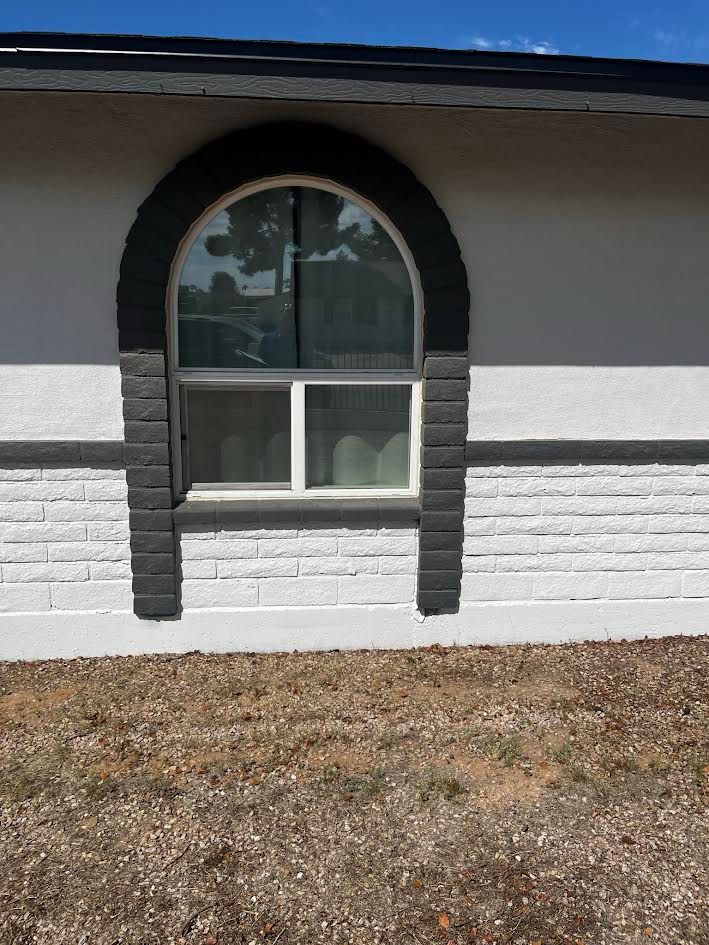 A house with a large arched window on the side of it.