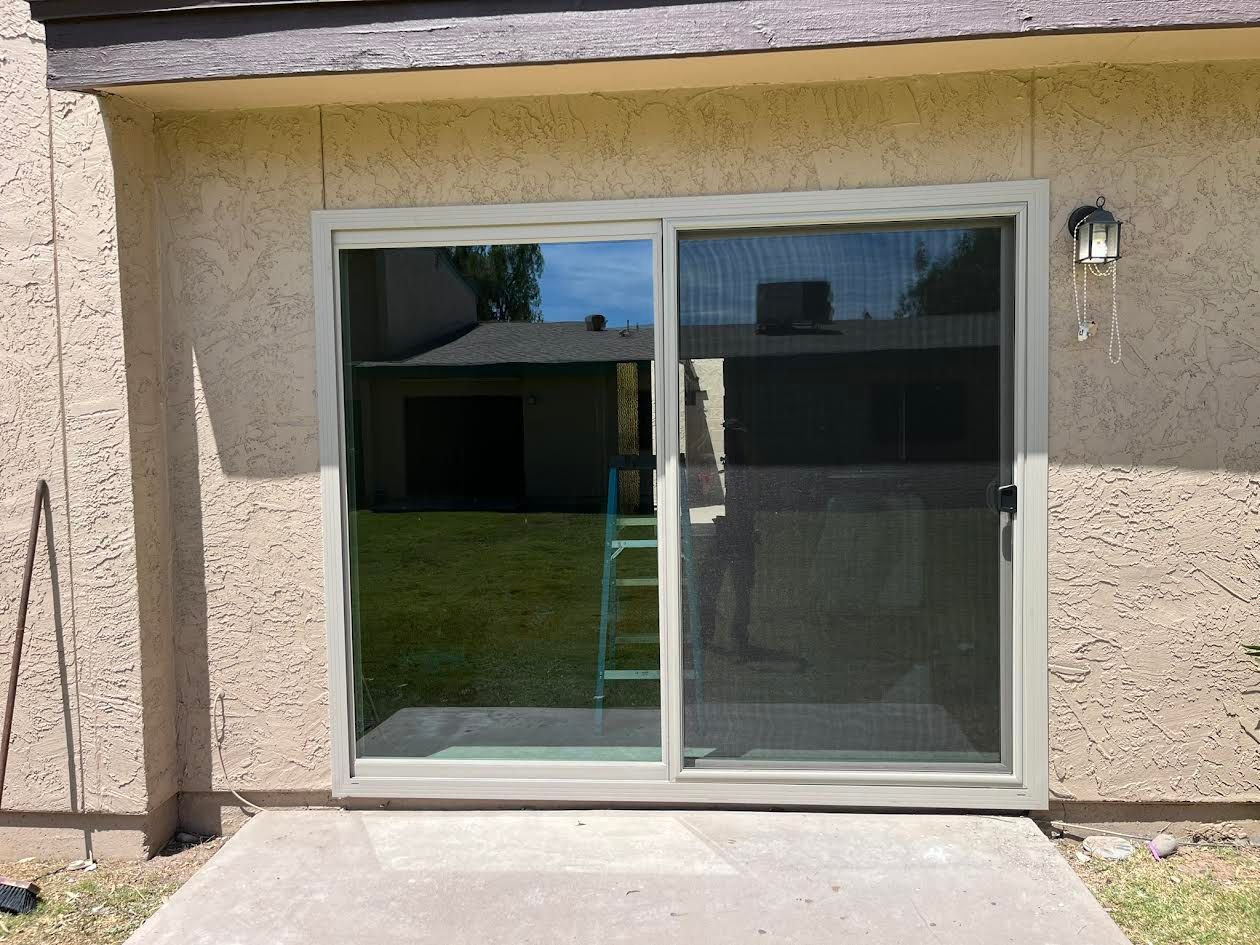 A sliding glass door with a ladder in the background