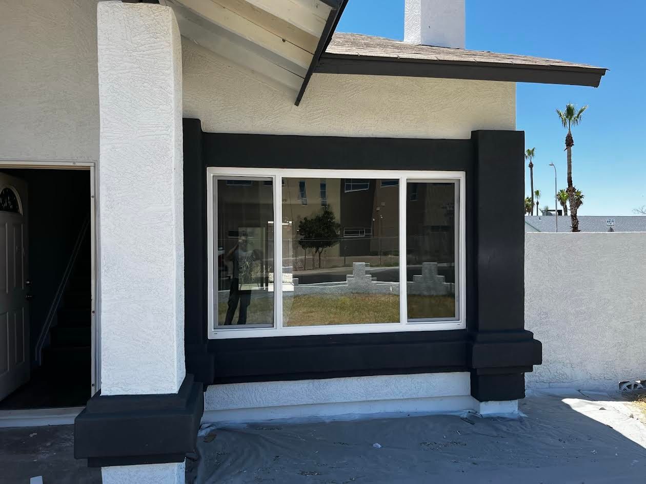 A white house with black trim and a large window