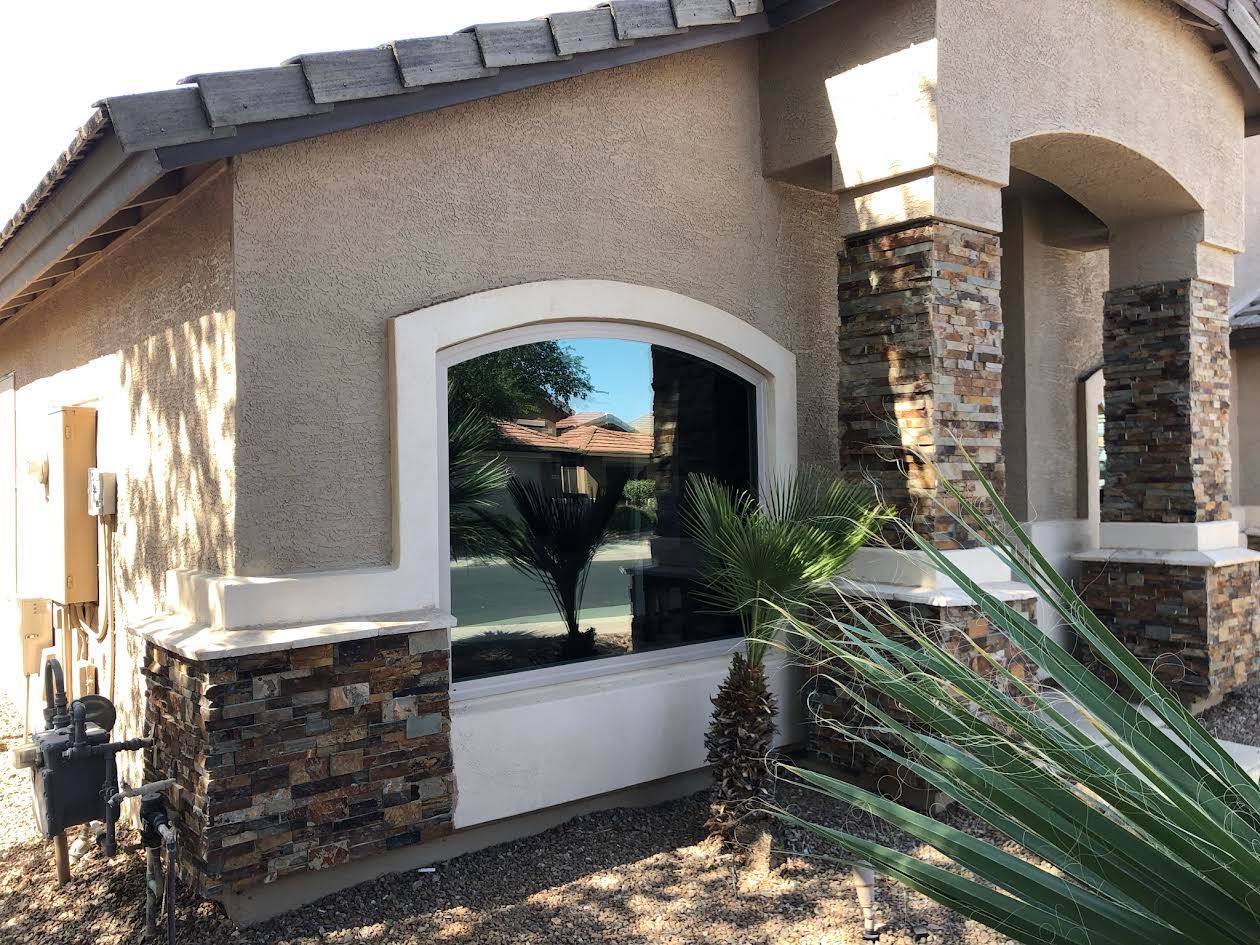 A house with a large window and a plant in front of it