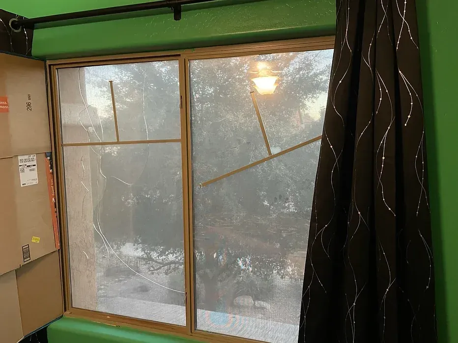 A window in a room with green walls and brown curtains