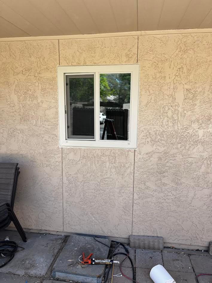 A window is being installed on the side of a house.