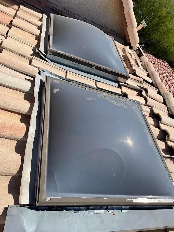 There are two skylights on the roof of a house.