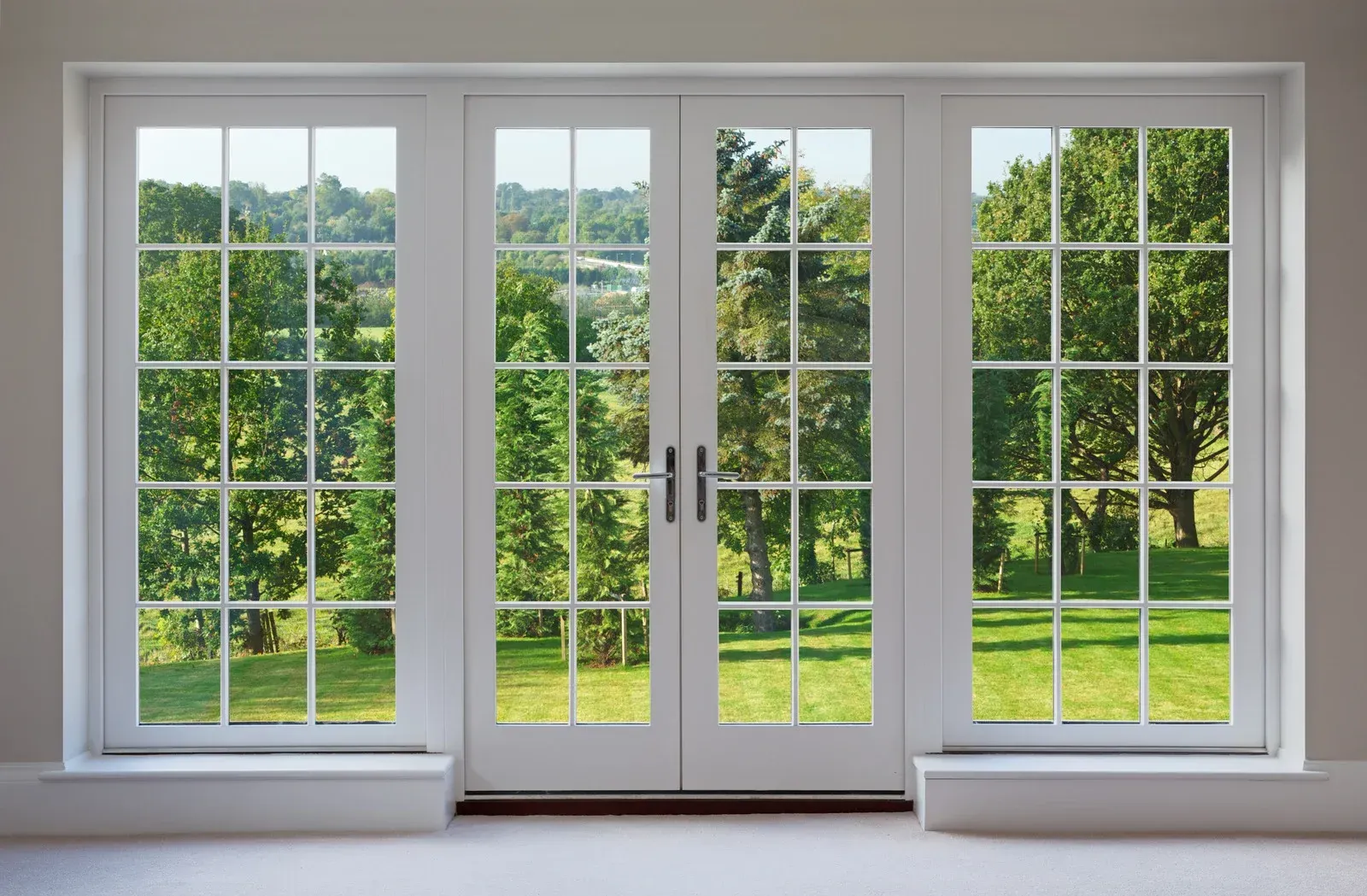 A large window with a view of a lush green field