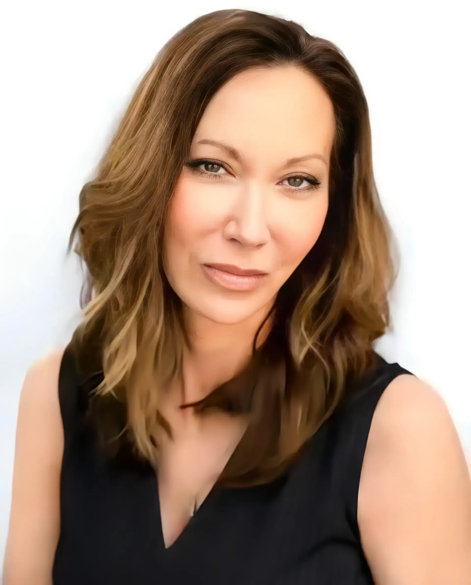A headshot of a woman with long brown hair, looking toward the camera with a neutral expression against a white background.