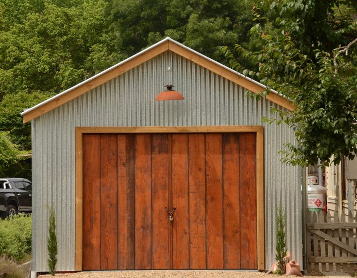 New Iron Shed With Double Wooden Doors — Garages & Sheds in Coffs Harbour, NSW