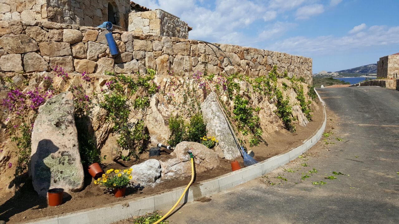 Un muro di pietra a cui è attaccato un tubo