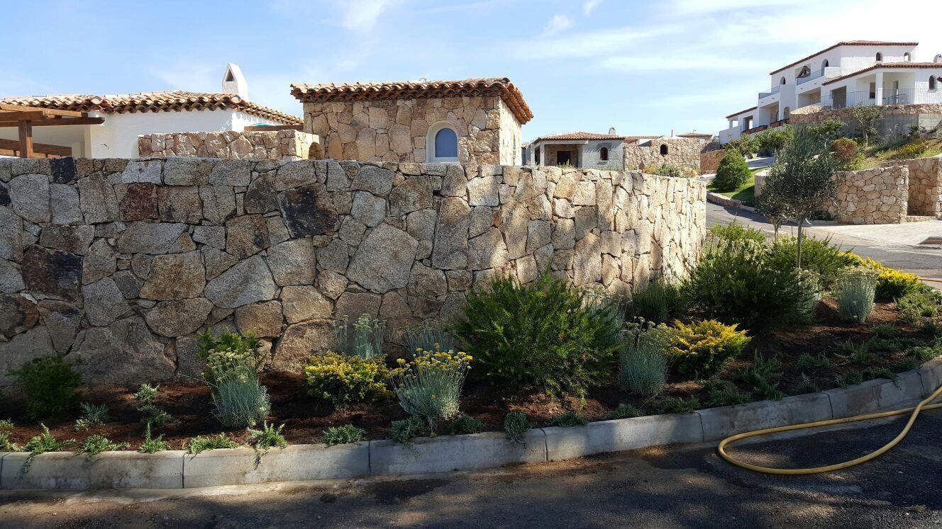 Un muro di pietra con una casa sullo sfondo