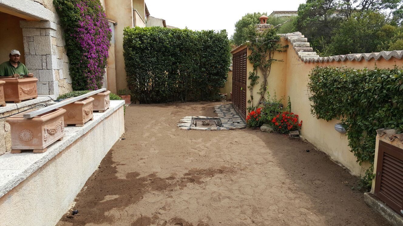 Un cortile con una recinzione e alcune piante in vaso
