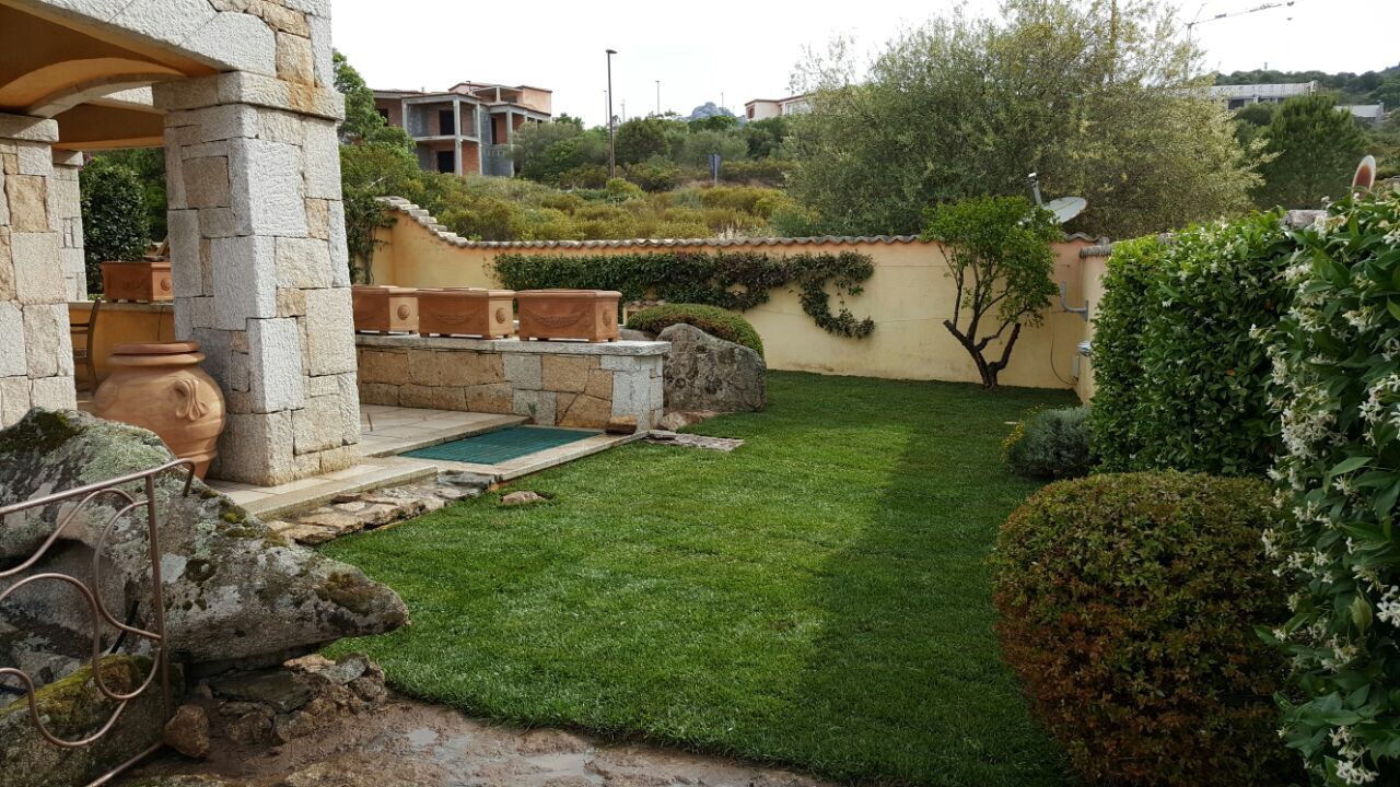 Un prato verde lussureggiante con un muro di pietra sullo sfondo