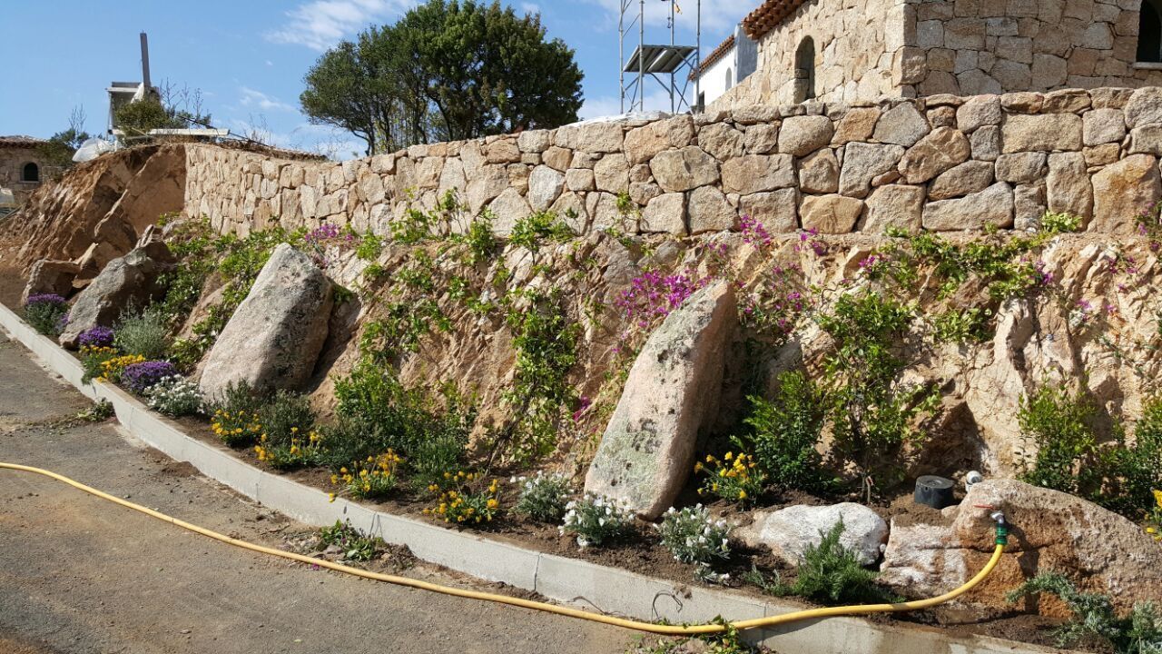 Un muro di pietra a cui è attaccato un tubo