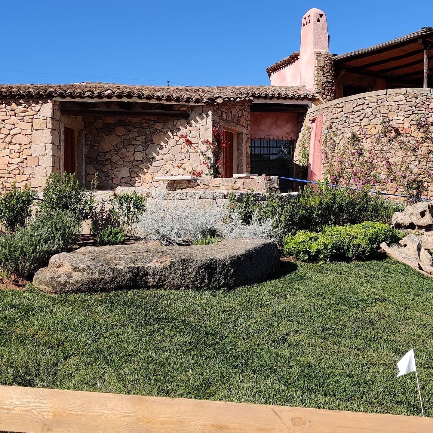 Una casa in pietra con una grande roccia davanti