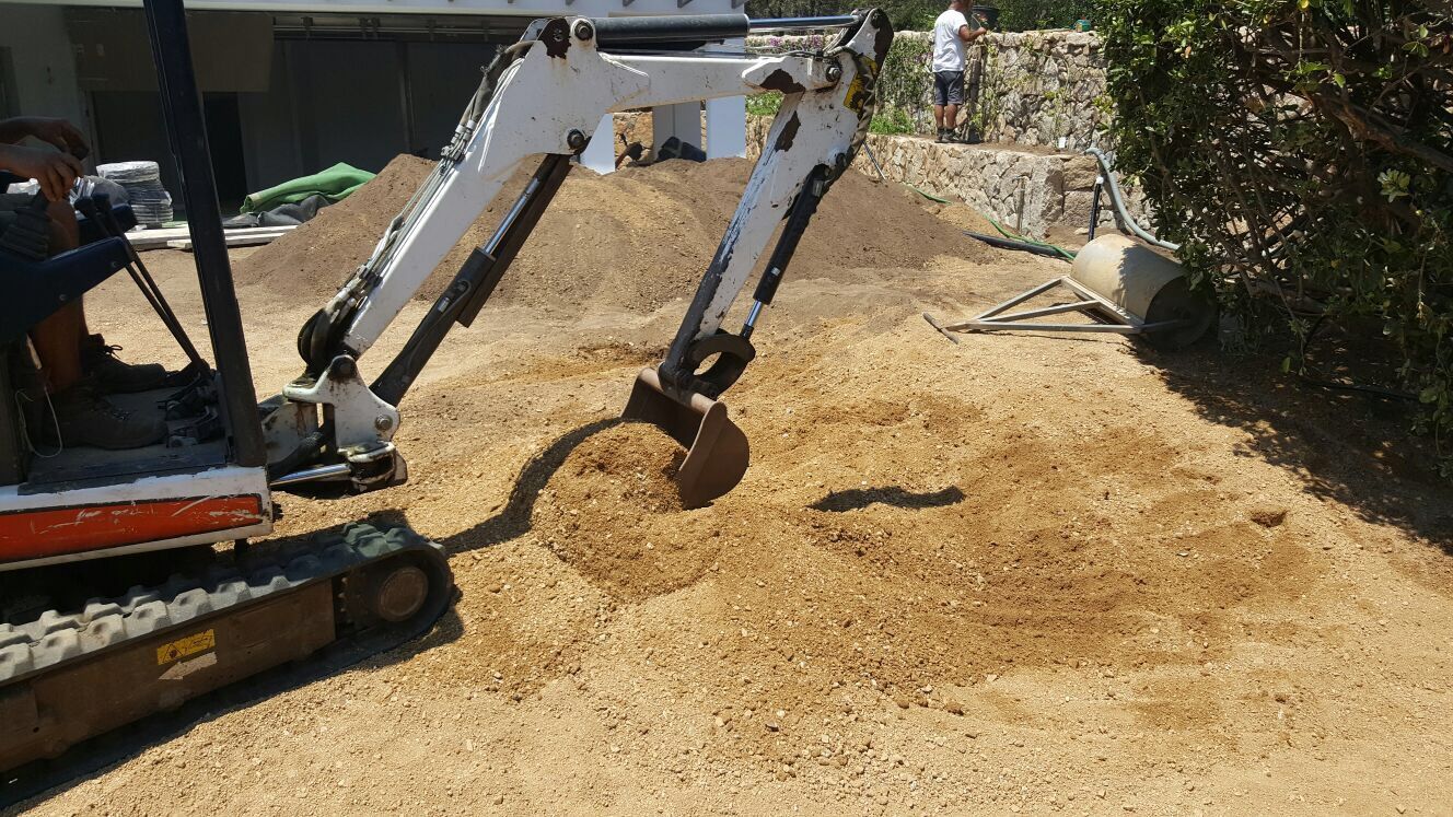Un piccolo escavatore sta scavando una buca nel terreno.