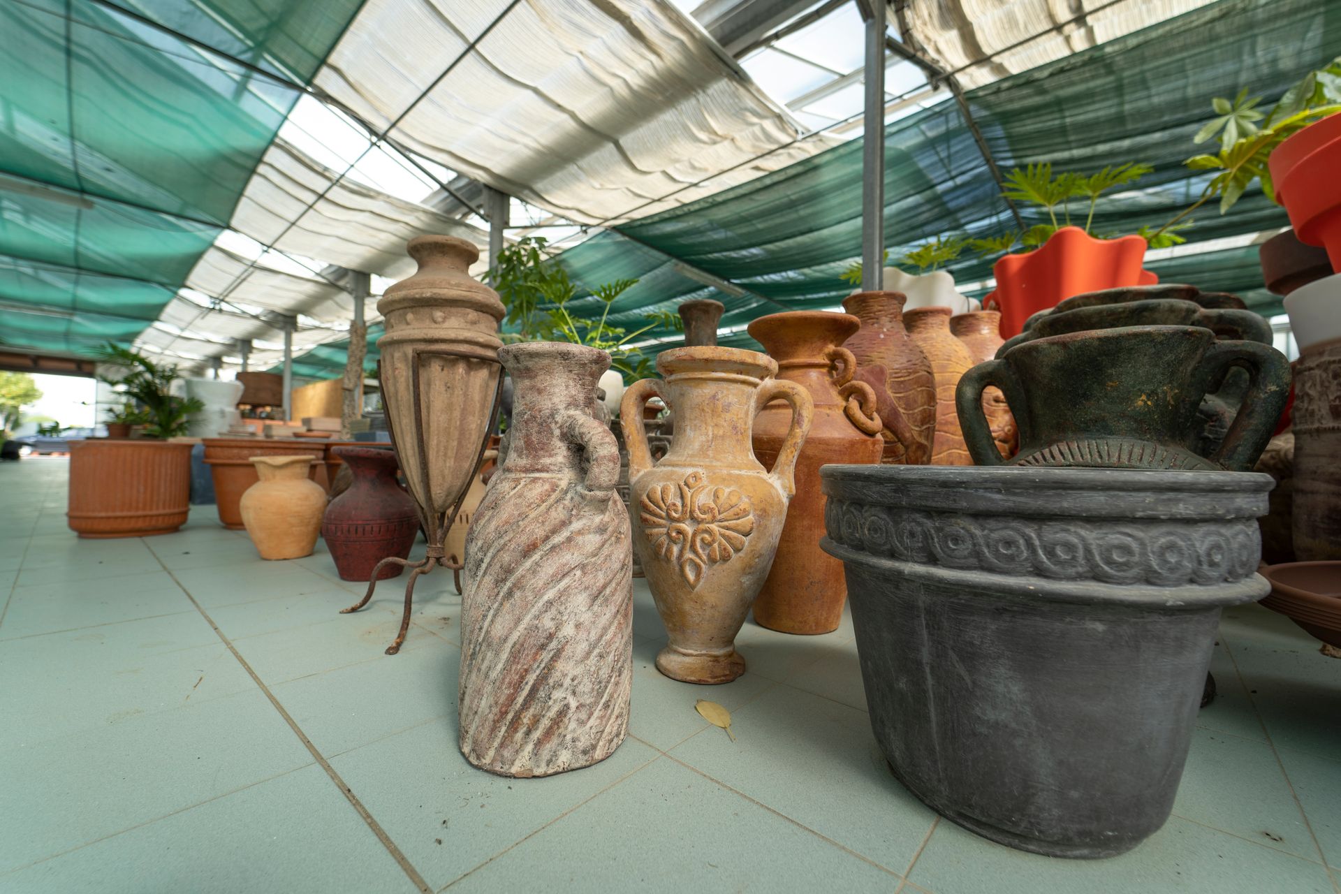 Una fila di vasi e vasi sono allineati in una serra.