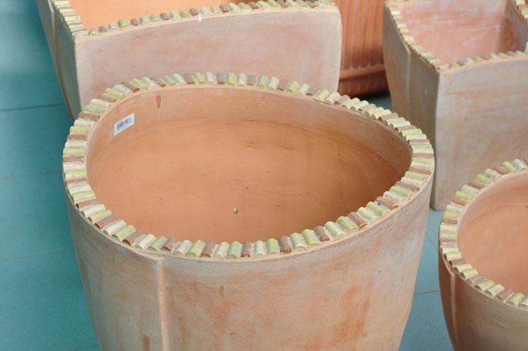 Un gruppo di vasi di terracotta posti uno sopra l'altro su un tavolo.