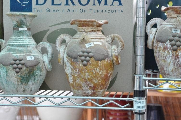 Tre vasi su uno scaffale davanti ad un cartello che dice terracotta