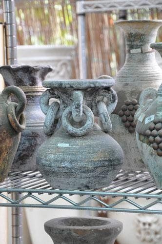 Sopra uno scaffale di metallo è appoggiato un mazzo di vasi.