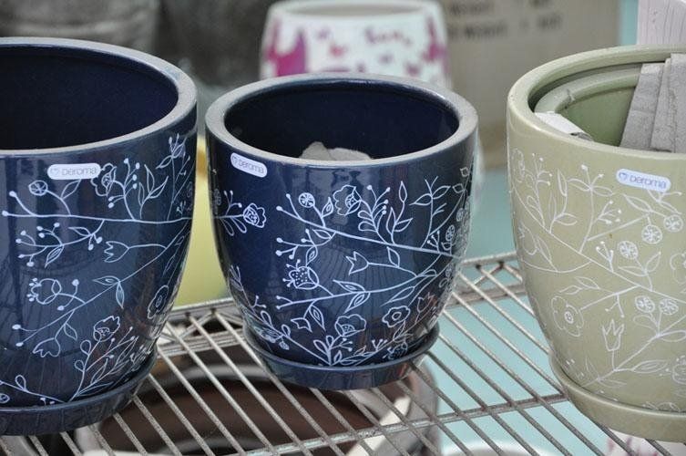 Su uno scaffale sono posizionati tre vasi di colore diverso.