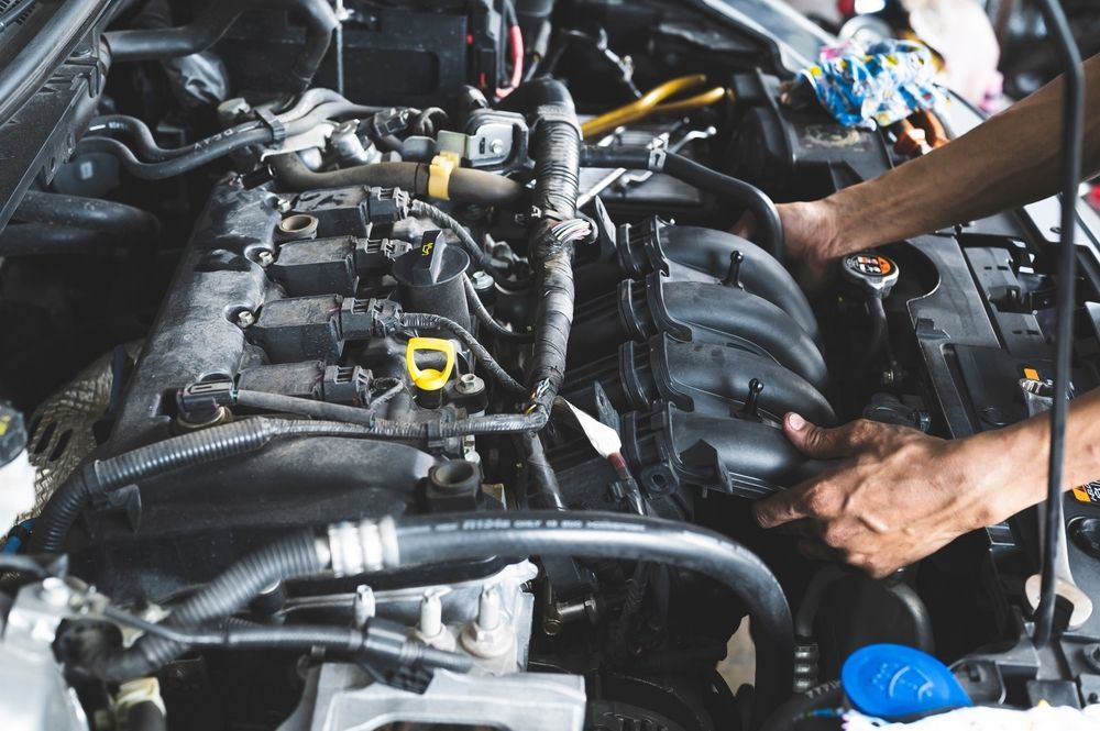 A Person's Hands Using a Wrench to Work on A Car Engine — Wallsend Automotive in Maryland, NSW
