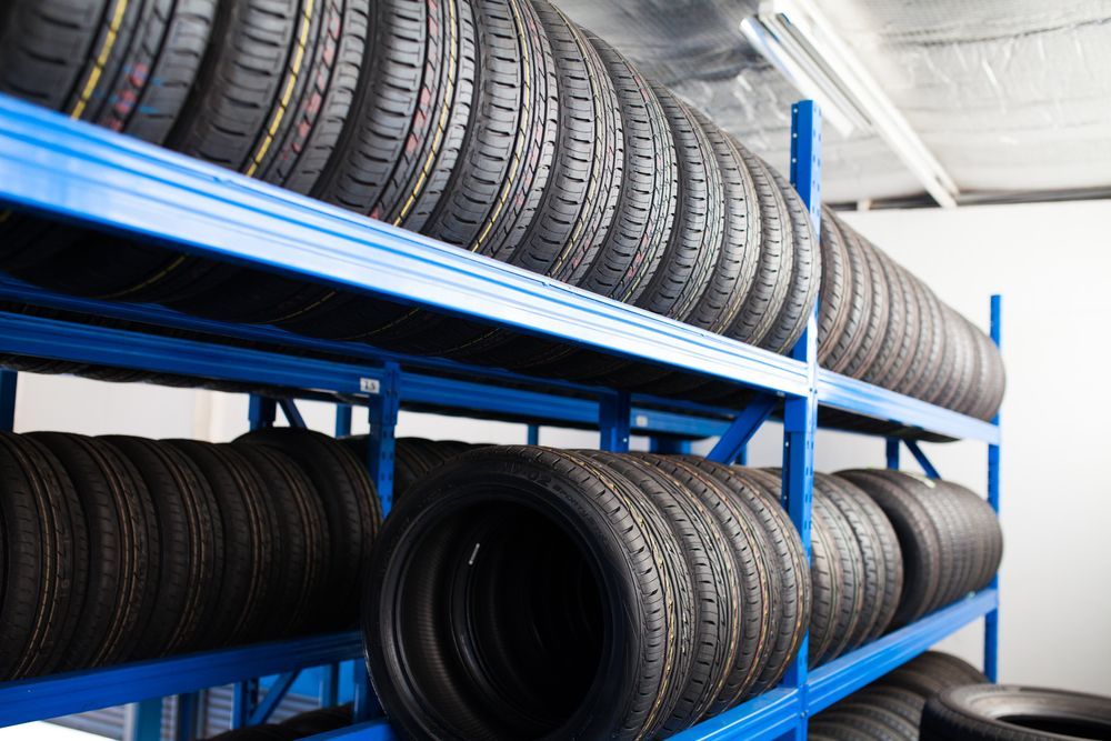 Tires Stacked on Blue Metal Shelves in A Garage — Wallsend Automotive in Maryland, NSW