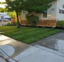 A house with a lush green lawn in front of it.
