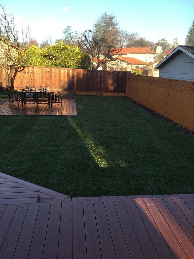 A backyard with a wooden deck and a wooden fence