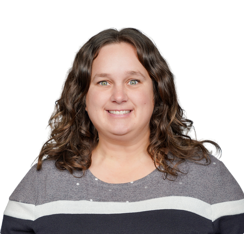 Smiling woman with wavy brown hair wearing a gray and navy striped sweater on a white background