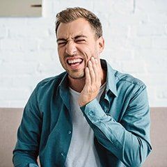 Man Holding Cheeks — The Center for Sleep Apnea and TMJ — Boise, ID