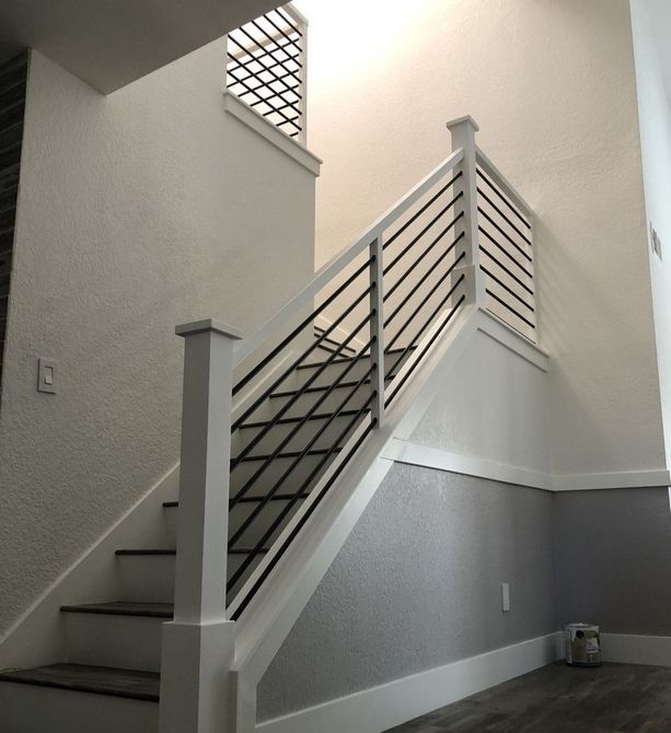 Modern Style Staircase Design in all white with square railing and square posts with flat post hat and horizontal black round bars 