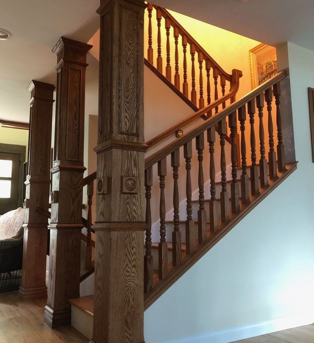 Traditional rich colored red oak stair railing with turned wooden balusters and custom wrapped columns