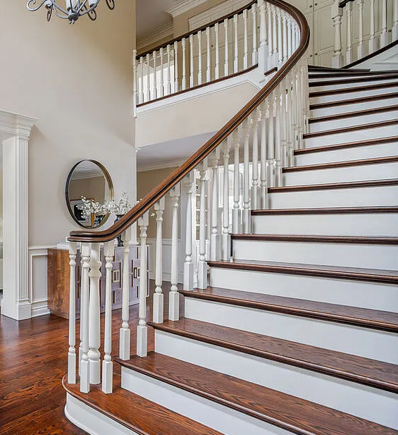 Traditional style staircase with over volute and white painted balusters