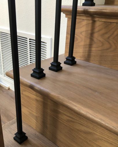 Solid stained oak hardwood treads stained oak risers with black iron balusters