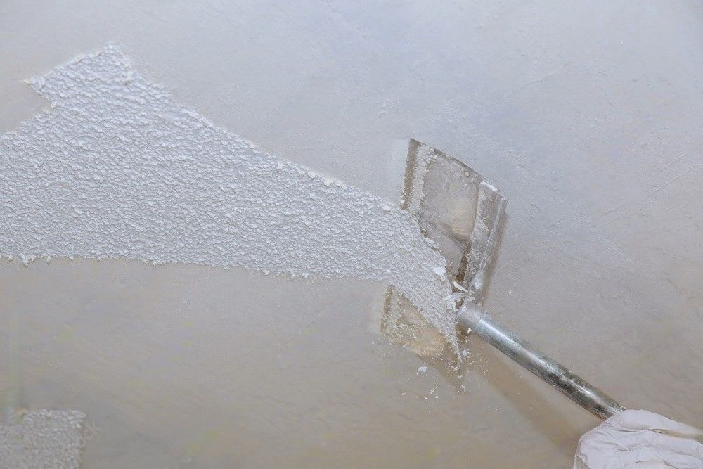 Ceiling drywall demolition in progress with removal of popcorn ceiling texture.