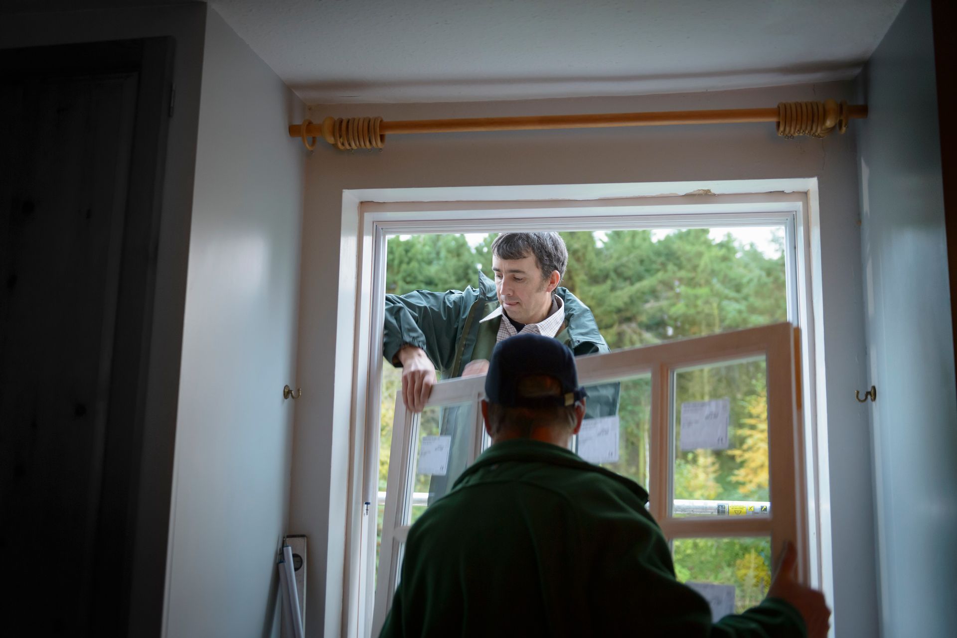 Builders installing a new energy-efficient window during a home replacement project.