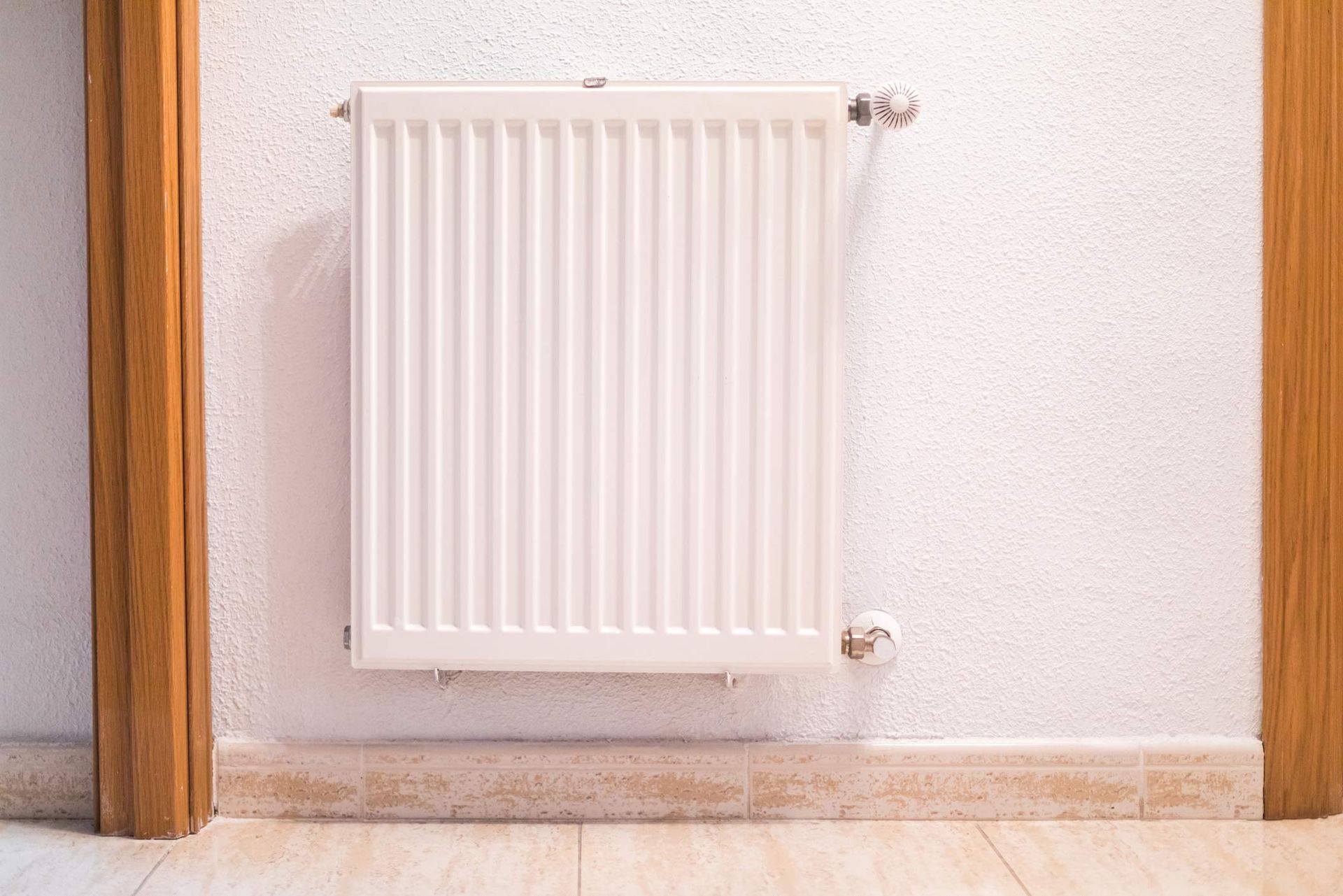 White home furnace, placed on a wall inside a house.