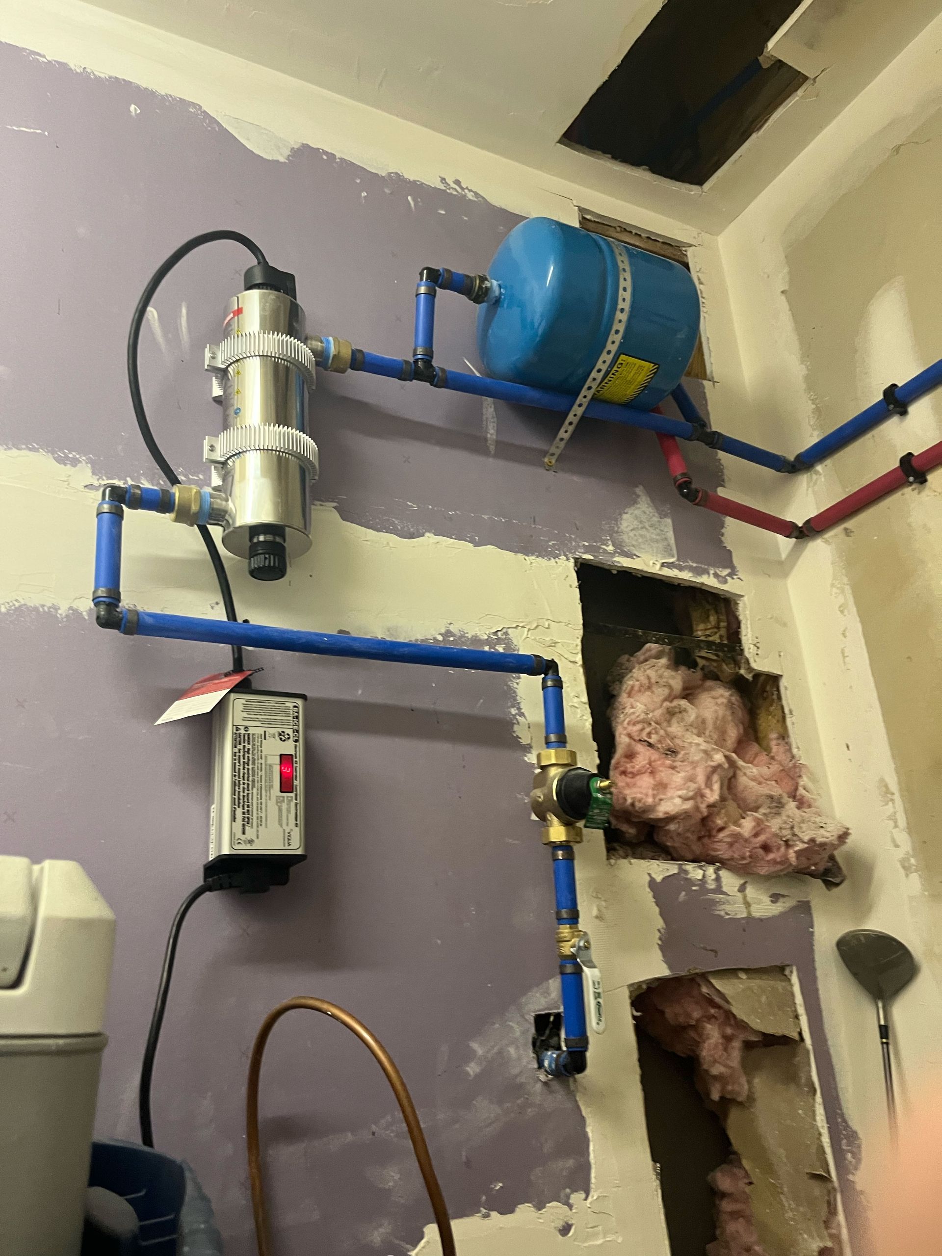 A room with a purple wall and blue pipes